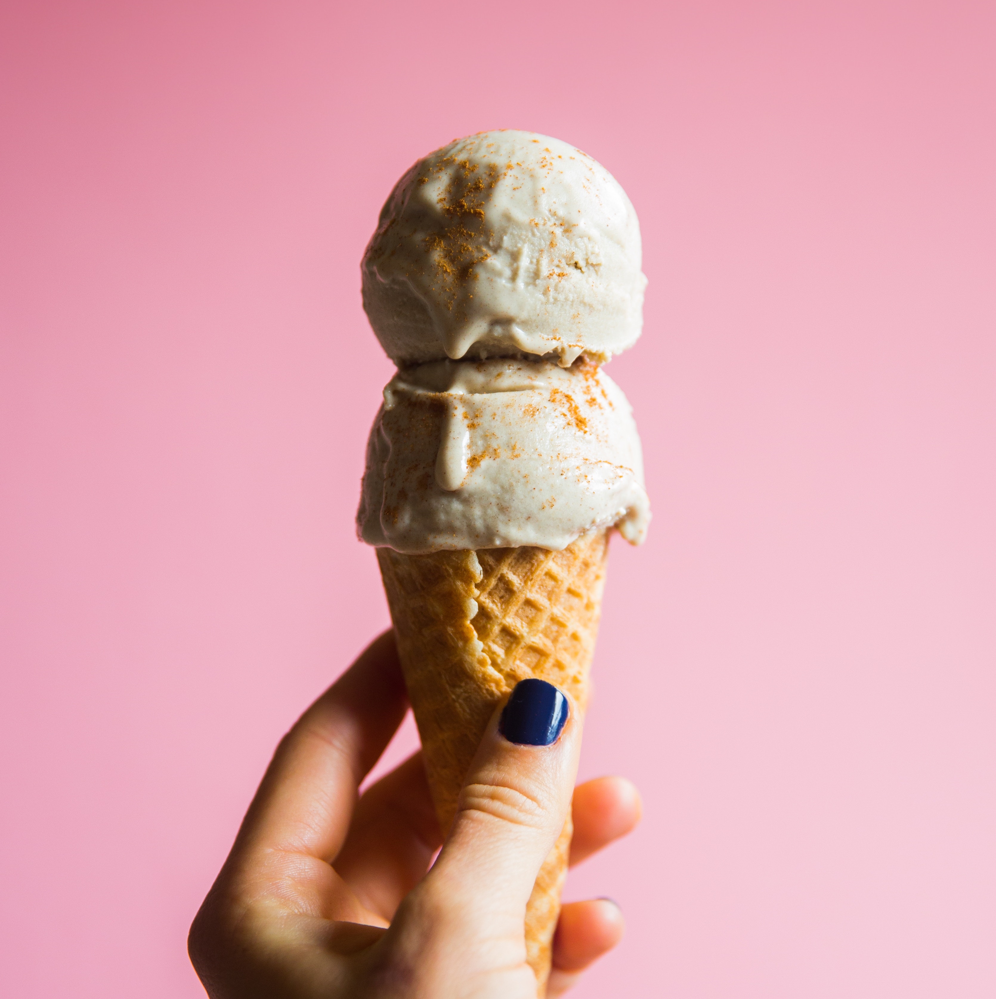 Hand holds ice cream cone. Photo by Rachael Gorjestani on Unsplash